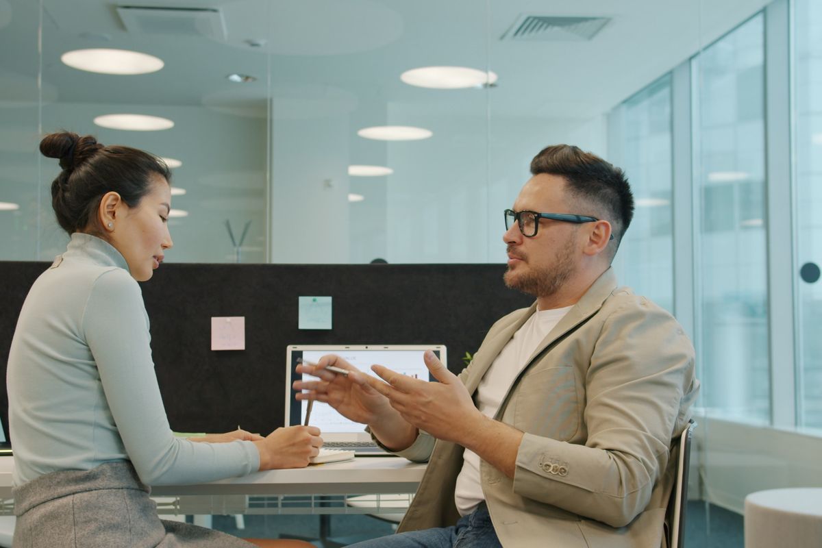 Two colleagues going through work at a shared desk