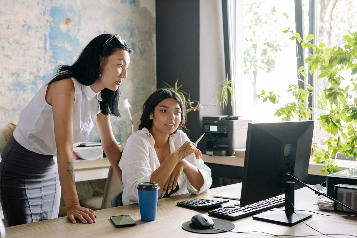 Colleagues talking through the day at a desk