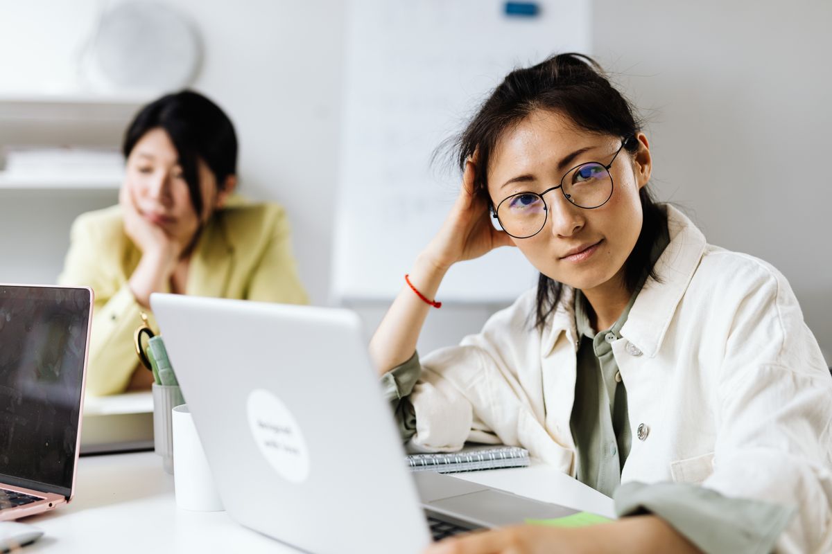 Two people working side by side at laptops